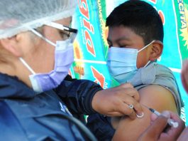 Un niño es vacunado por el personal municipal de salud contra la Covid-19. Foto: AMUN